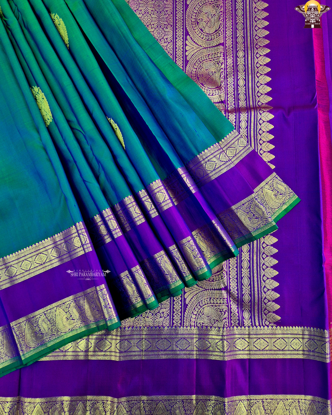 A elegant teal blue (peacock blue) body with a rich contrast purple/violet border Saree
