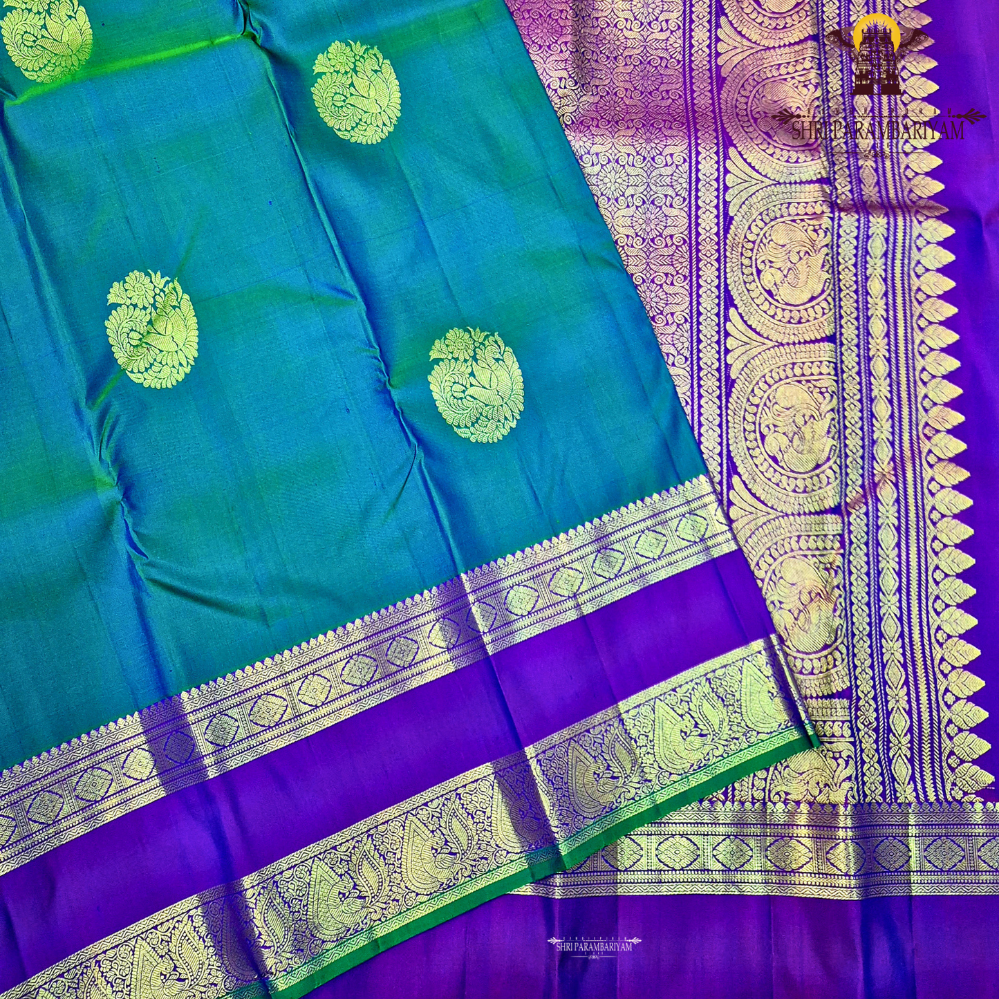 A elegant teal blue (peacock blue) body with a rich contrast purple/violet border Saree