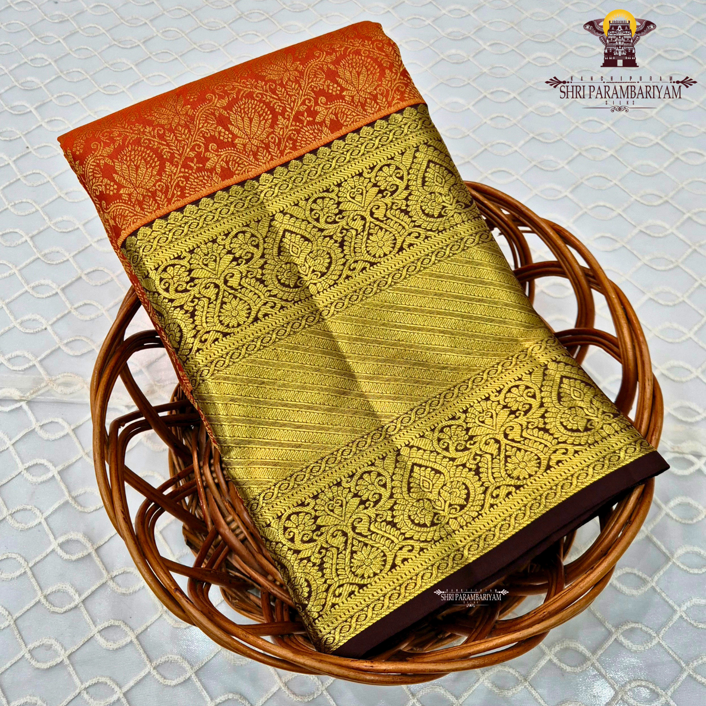 A bright orange with a rich coffee brown and gold korvai border Saree