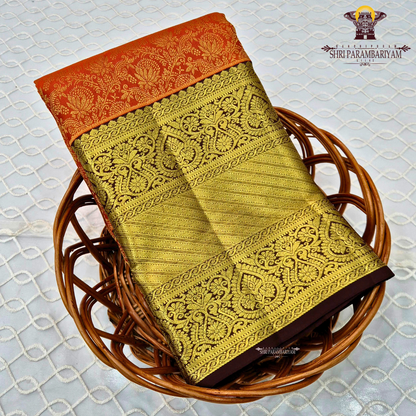 A bright orange with a rich coffee brown and gold korvai border Saree