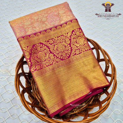 A soft peach tissue body paired with a rich magenta border Saree