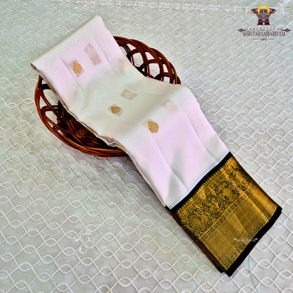 A graceful pearl white body adorned with delicate gold zari buttas, lending a refined and sophisticated Saree