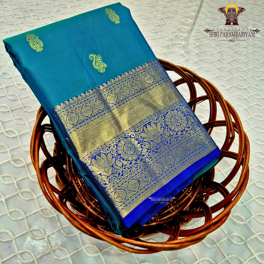 A rich Peacock Blue (teal blue tone) with Royal Blue and Gold zari border Saree