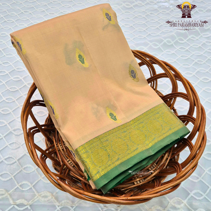 Soft peach-beige body paired with a rich parrot green 2-inch border and subtle gold zari detailing Saree
