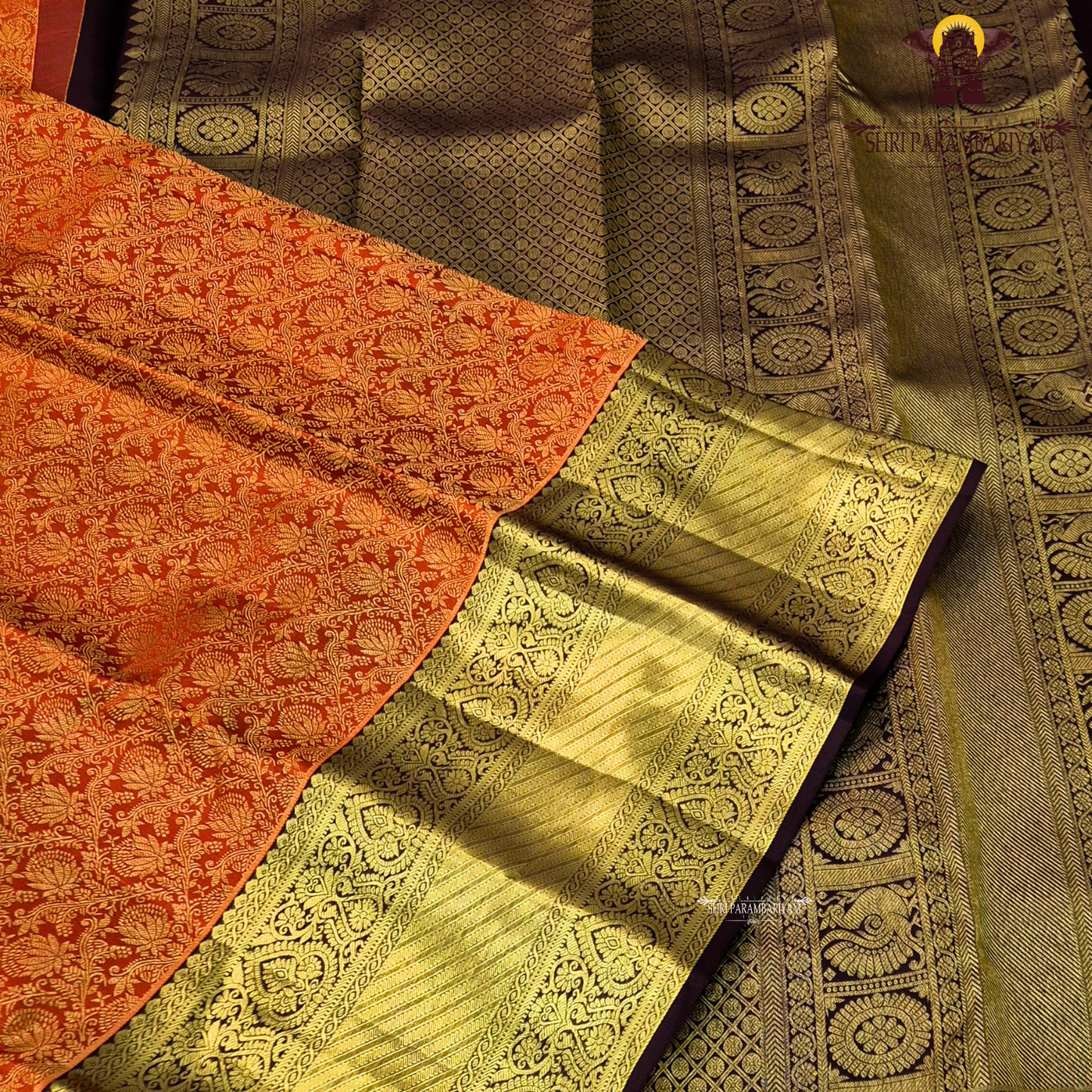 A bright orange with a rich coffee brown and gold korvai border Saree