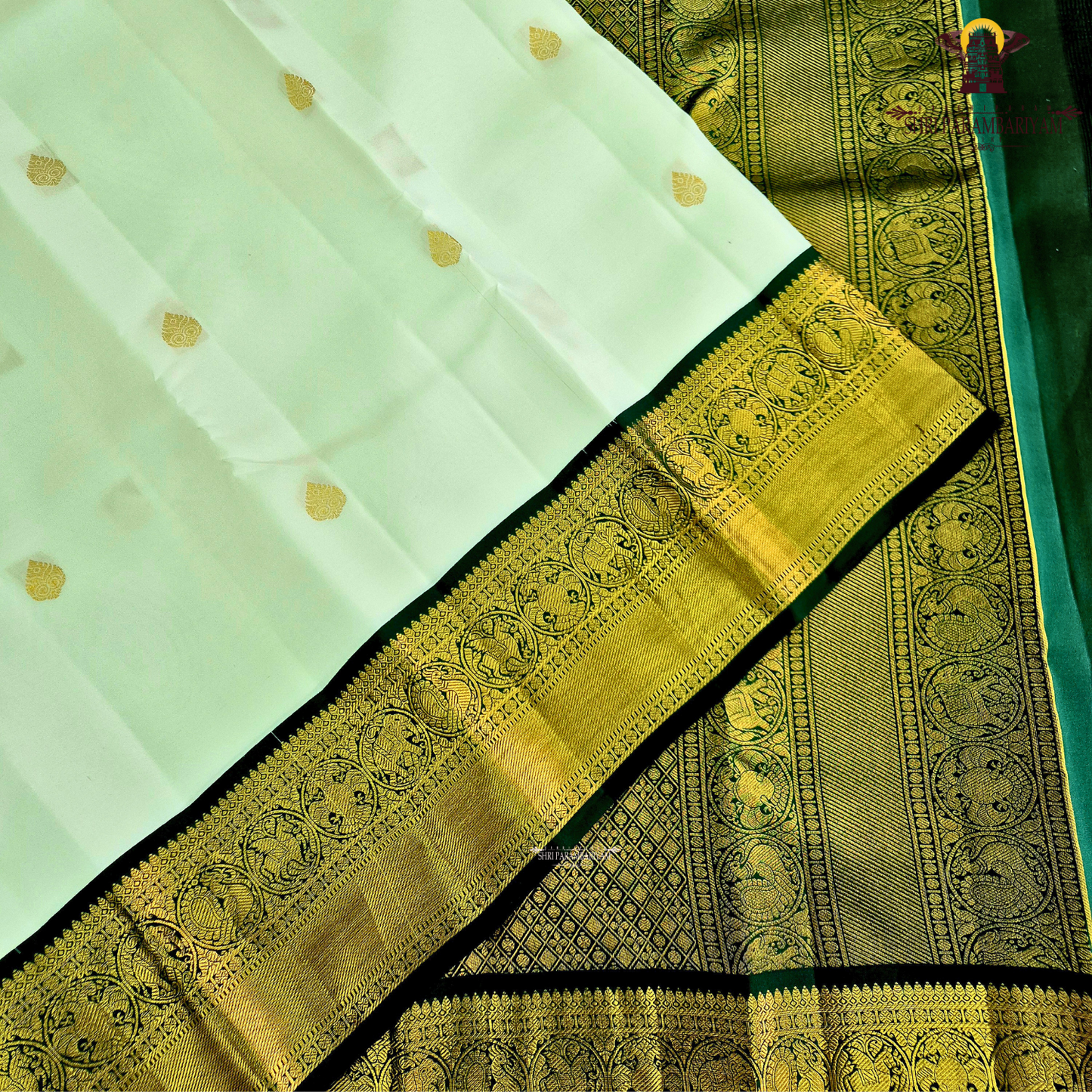 A graceful pearl white body adorned with delicate gold zari buttas, lending a refined and sophisticated Saree