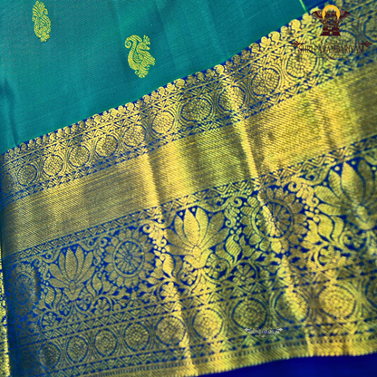 A rich Peacock Blue (teal blue tone) with Royal Blue and Gold zari border Saree