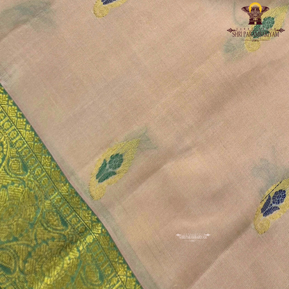 Soft peach-beige body paired with a rich parrot green 2-inch border and subtle gold zari detailing Saree