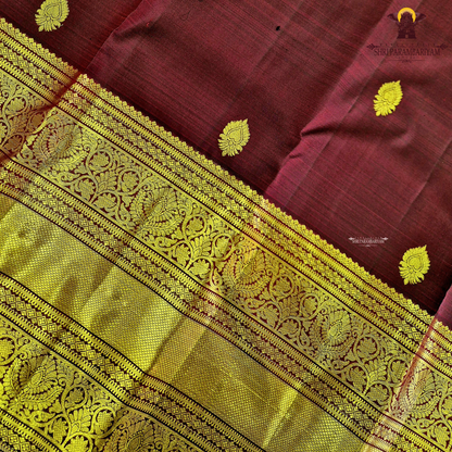 A rich wine maroon body with elegant gold zari butta Saree