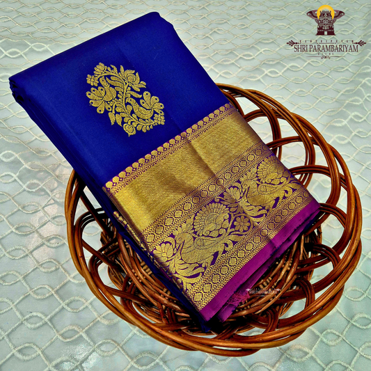 A deep royal blue with a rich gold zari border and a contrasting magenta (pink) edging Saree