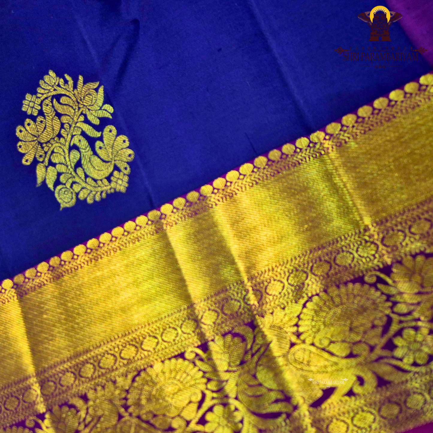 A deep royal blue with a rich gold zari border and a contrasting magenta (pink) edging Saree