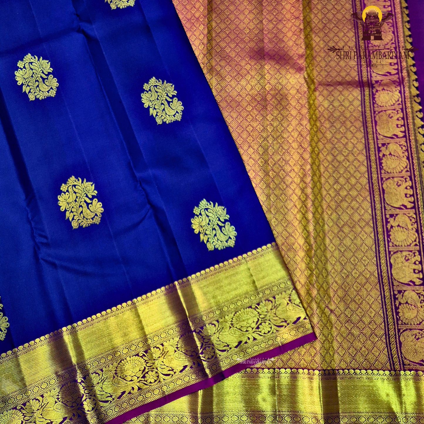 A deep royal blue with a rich gold zari border and a contrasting magenta (pink) edging Saree