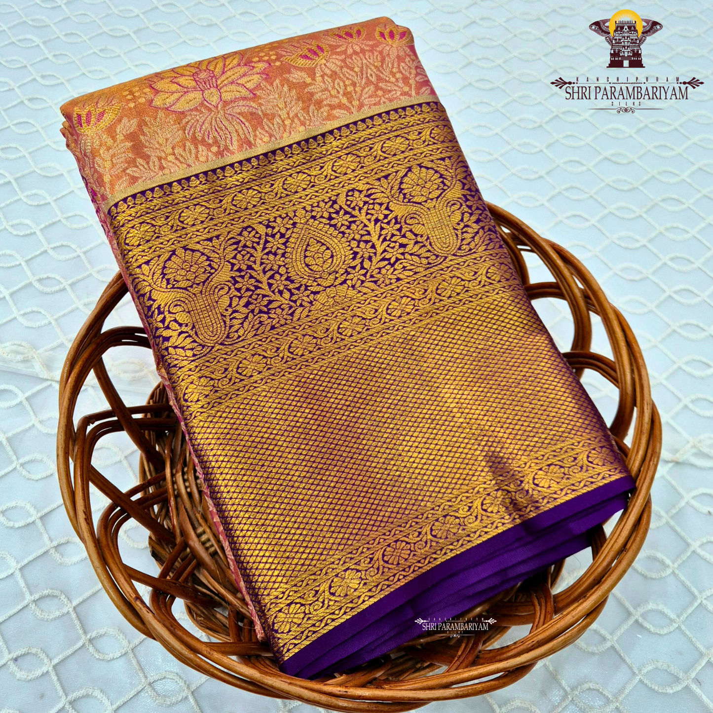 A rich combination of peachy orange body paired with a striking royal purple border Saree