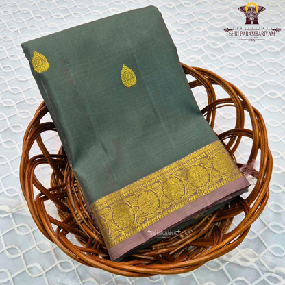 Elegant Dusty Green / Sage Green body with rich gold zari buttas, paired with a mustard gold zari 2-inch traditional border and subtle mauve selvedge edging Saree