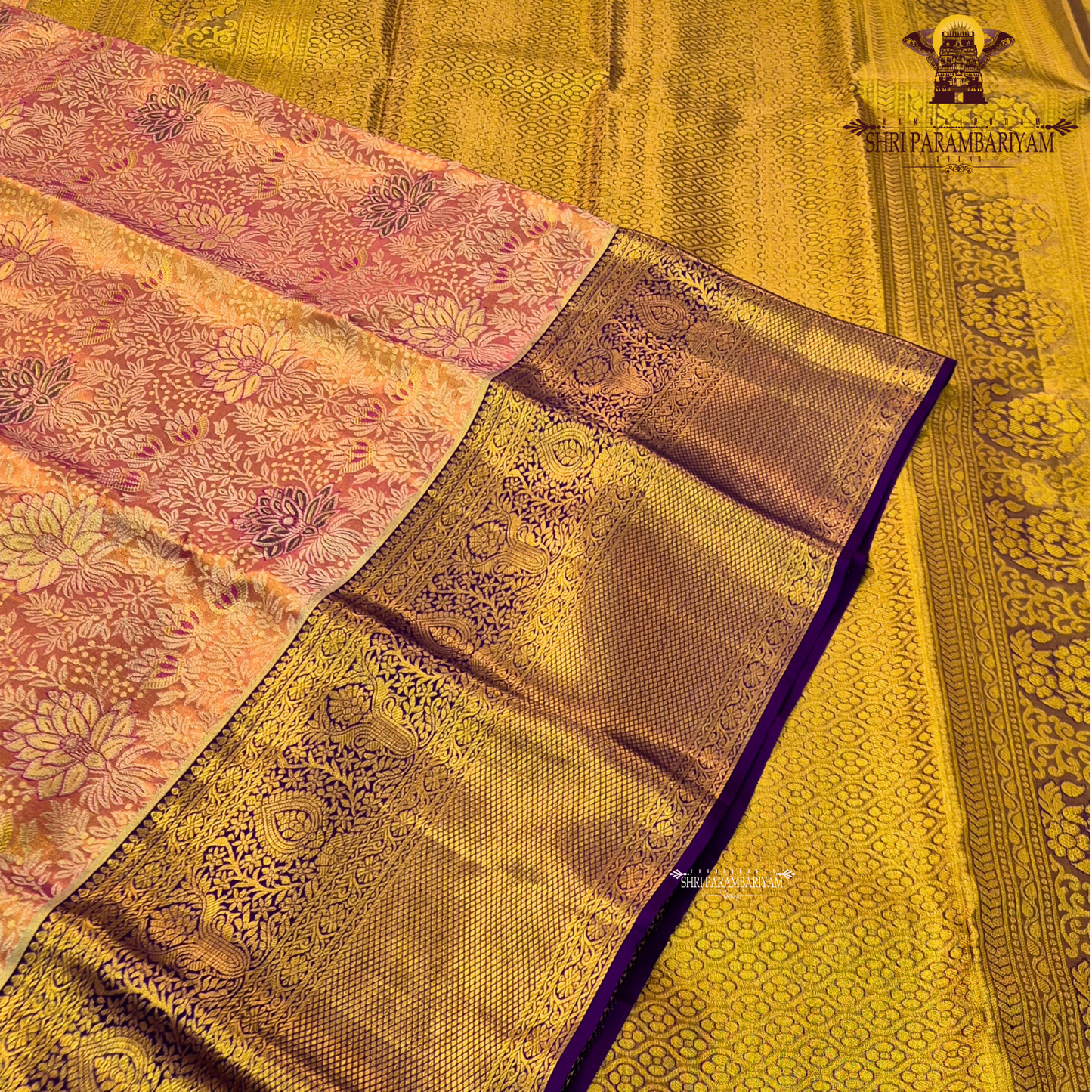 A rich combination of peachy orange body paired with a striking royal purple border Saree