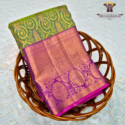 A vibrant parrot green body, paired with a rich purple (magenta-toned) korvai border Saree