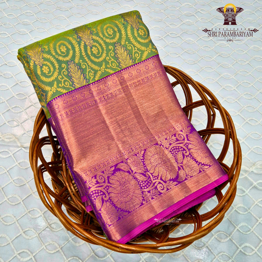 A vibrant parrot green body, paired with a rich purple (magenta-toned) korvai border Saree