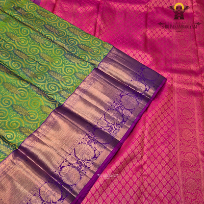 A vibrant parrot green body, paired with a rich purple (magenta-toned) korvai border Saree