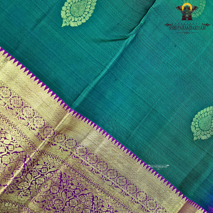 A rich bottle green with a gold zari border and a contrasting magenta (rani pink) edging Saree