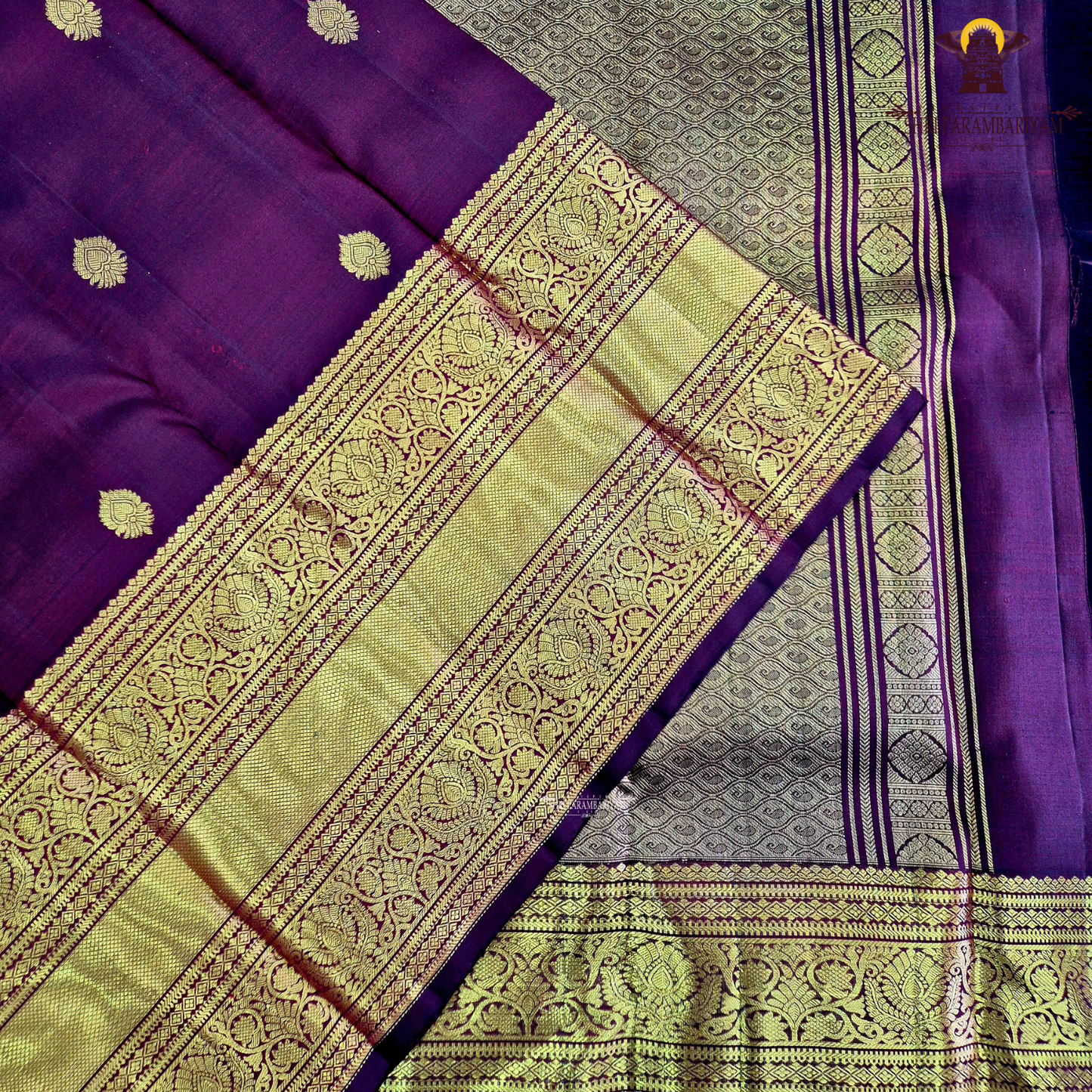 A rich wine maroon body with elegant gold zari butta Saree