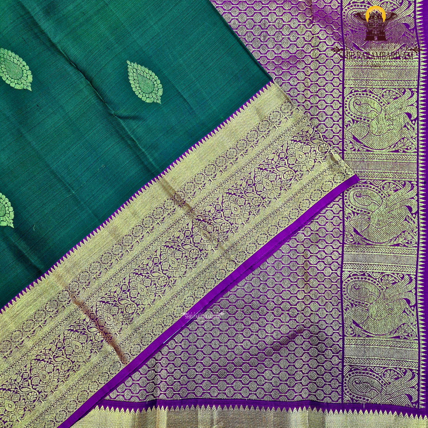 A rich bottle green with a gold zari border and a contrasting magenta (rani pink) edging Saree