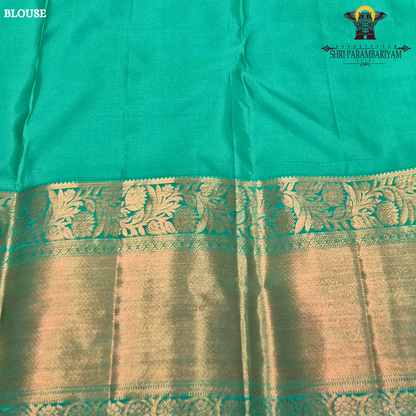 A rich royal purple body, paired with a contrasting emerald green korvai border Saree