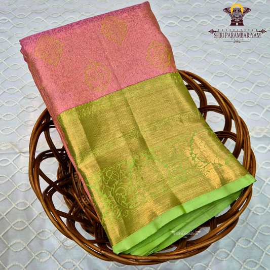 A soft rose pink body, paired with a refreshing parrot green korvai border Saree