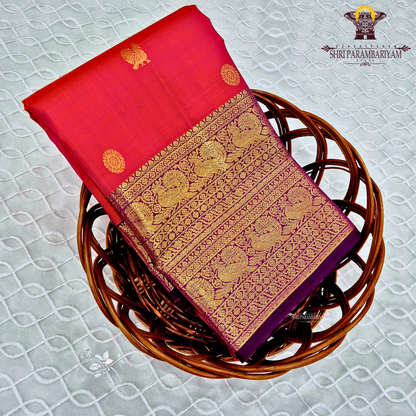A bright vermilion red with a rich violet/purple border Saree