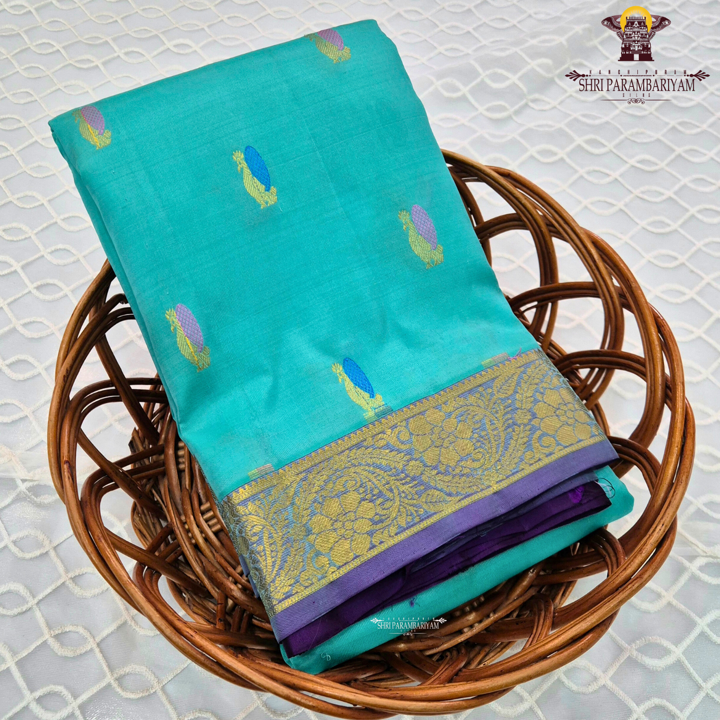 A vibrant turquoise blue / sea green body paired with a rich purple 2-inch border Saree