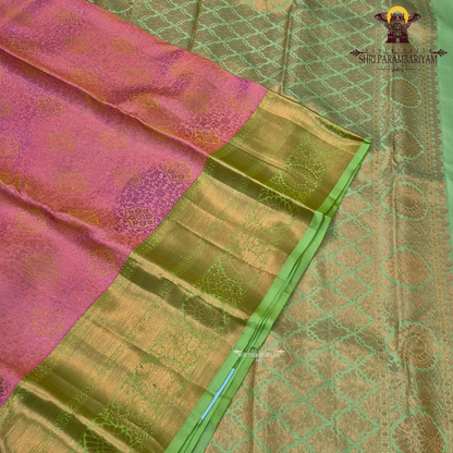 A soft rose pink body, paired with a refreshing parrot green korvai border Saree