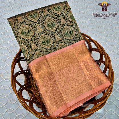 A deep bottle green with antique gold zari weaving, paired with a soft peach-pink korvai border Saree