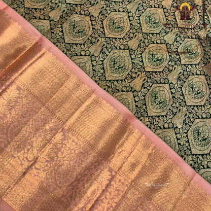 A deep bottle green with antique gold zari weaving, paired with a soft peach-pink korvai border Saree