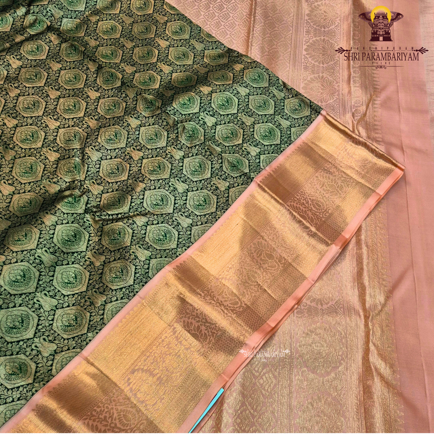 A deep bottle green with antique gold zari weaving, paired with a soft peach-pink korvai border Saree