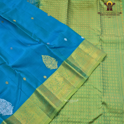 Elegant teal blue (peacock blue tone) with a rich contrast of gold zari and parrot green border Saree