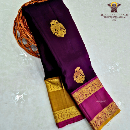 A rich deep violet / royal purple body paired with contrast magenta (pink) and antique gold tones Saree