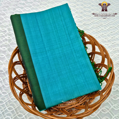 A soothing turquoise blue body complemented by a contrasting dark bottle green border Saree