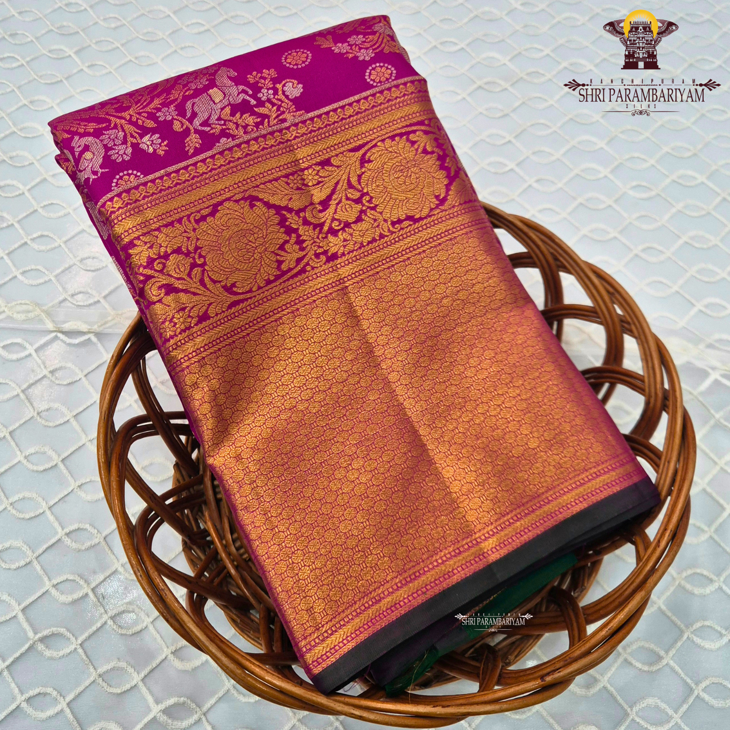 A rich magenta pink body with a contrasting dark green border Saree
