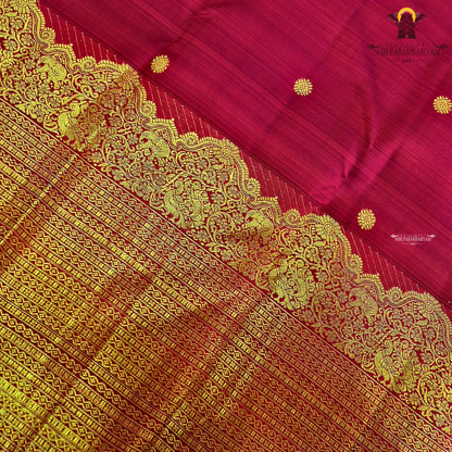 A vibrant ruby red body enhanced with delicate gold zari buttas Saree