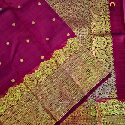 A vibrant ruby red body enhanced with delicate gold zari buttas Saree
