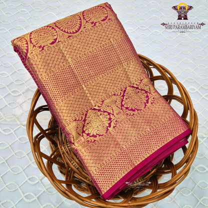 A rich and regal deep magenta / rani pink base adorned with opulent antique gold zari work Saree