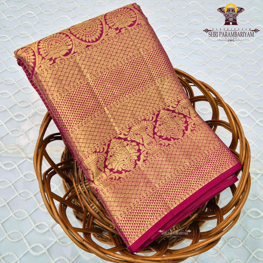 A rich and regal deep magenta / rani pink base adorned with opulent antique gold zari work Saree