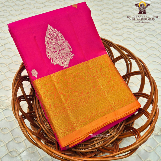 Bright rani pink (vibrant magenta tone) with a rich gold zari border and orange edging Saree