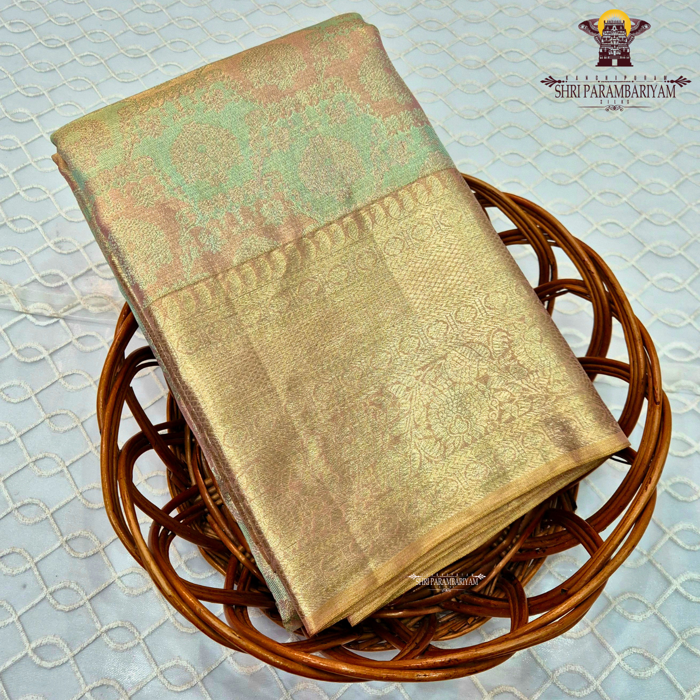 A rich antique gold tissue base blended with pastel mint green and soft peach tones Saree