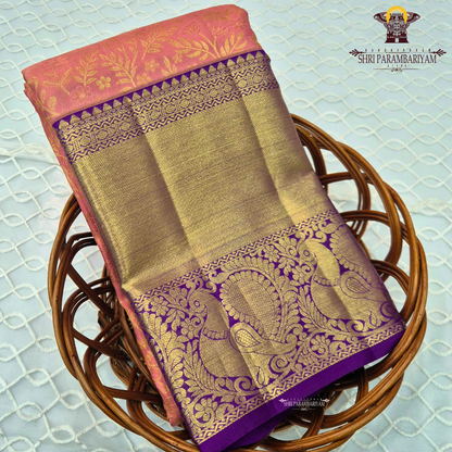 A soft peach pink body paired with a rich royal purple korvai border Saree