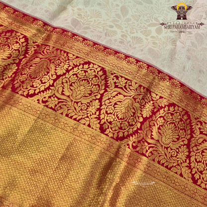 Soft cream/ivory body paired with a striking deep red border Saree