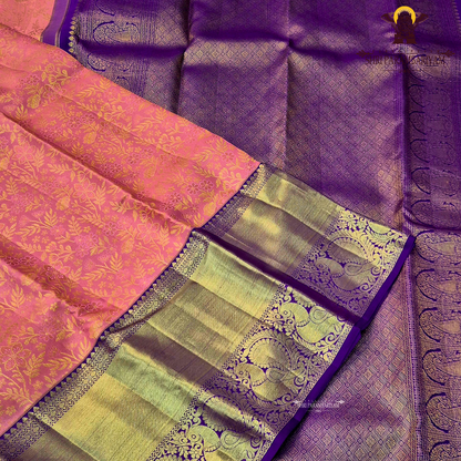 A soft peach pink body paired with a rich royal purple korvai border Saree