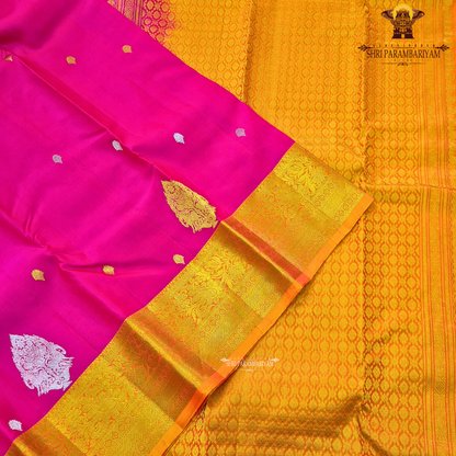 Bright rani pink (vibrant magenta tone) with a rich gold zari border and orange edging Saree