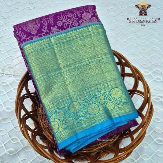 A rich violet purple body with a contrasting sky blue korvai border Saree