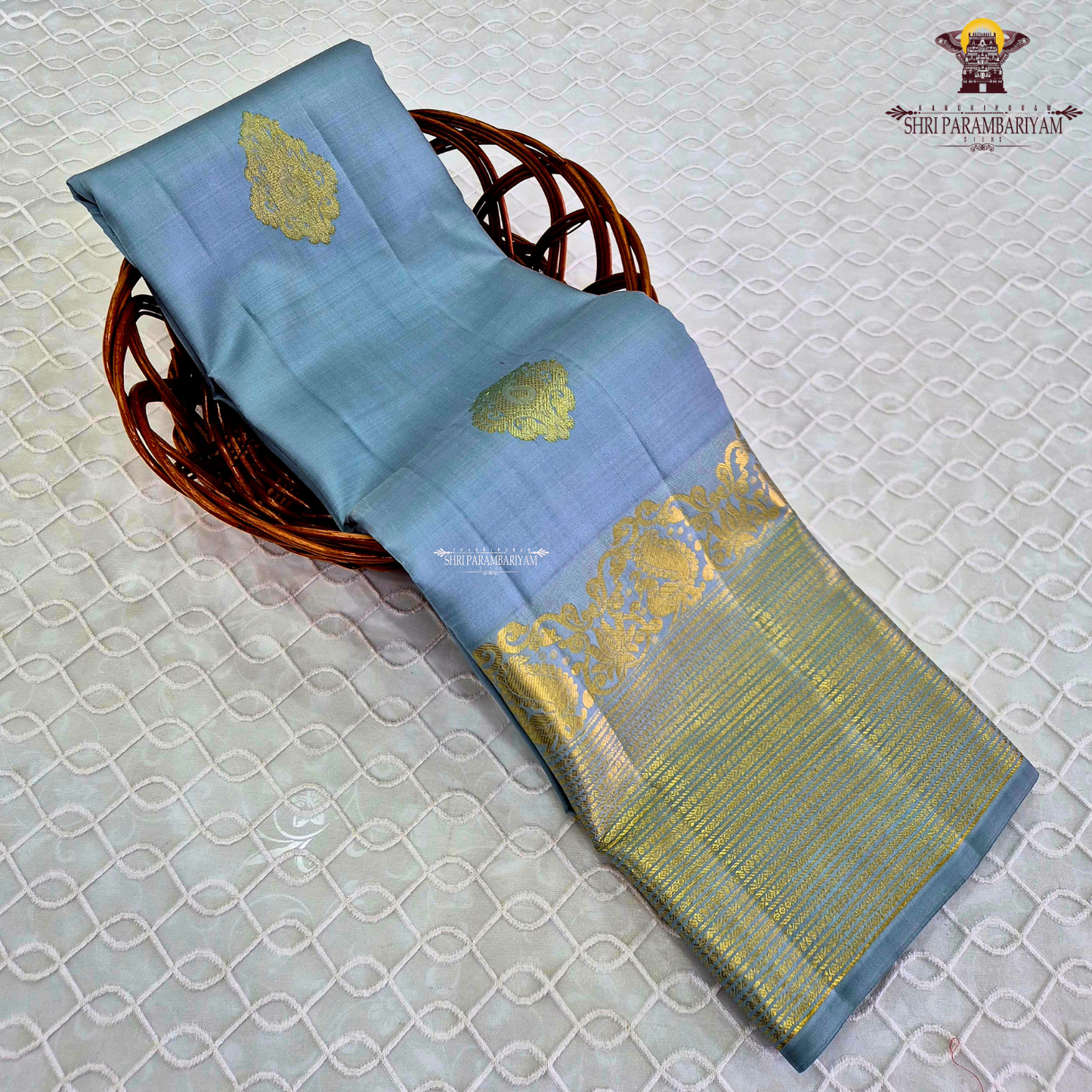 A soothing Ice Blue shade, adorned with graceful gold zari floral buttas Saree