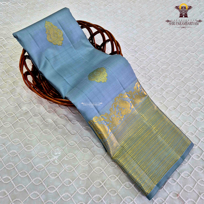 A soothing Ice Blue shade, adorned with graceful gold zari floral buttas Saree